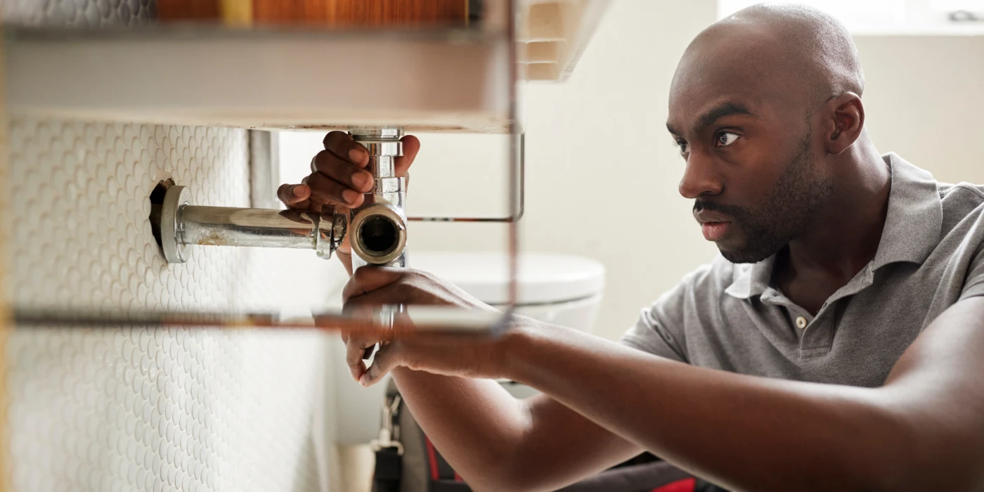 a male plumber fixing a pipe connection from Houston Plumbing Repair in Houston, TX - Plumber 